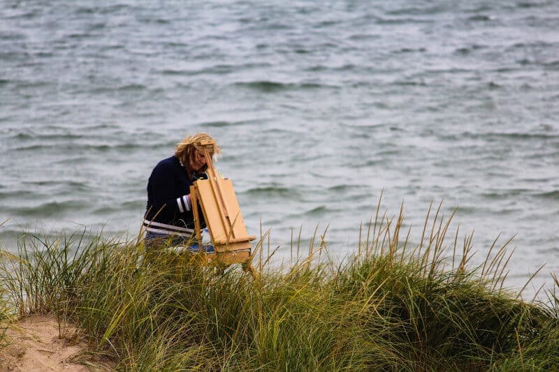 Picture of someone painting at an easel. Painting and arts and crafts are recommended for those suffering from dementia.