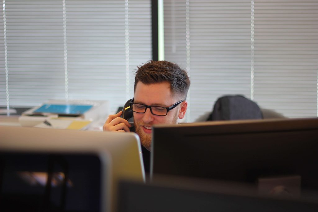 A member of a social care team on the phone at a desk, coordinating support for the people they work with