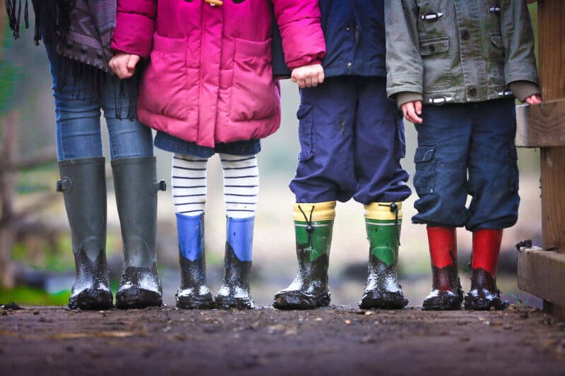 Two children in wellington boots standing outdoors